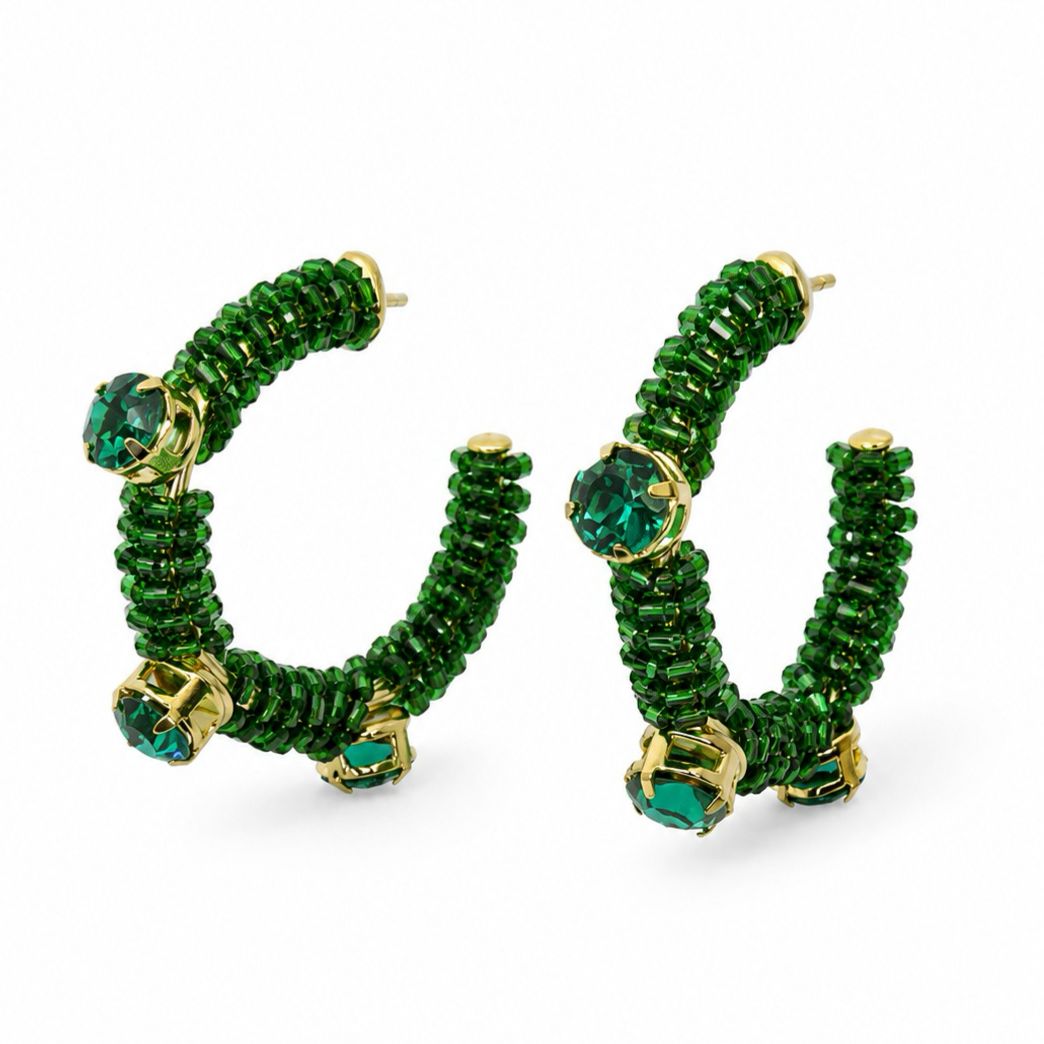 Par de brincos em formato de argola aberta, tecidos em crochê verde e decorados com cristais verdes em detalhes dourados.